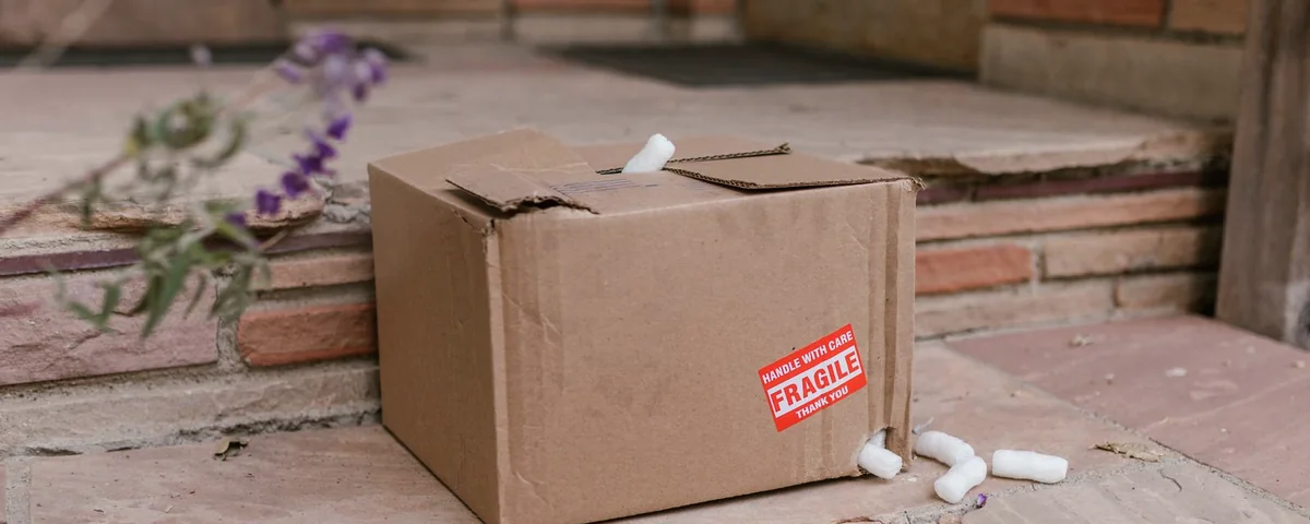 Carton endommagé avec un autocollant FRAGILE