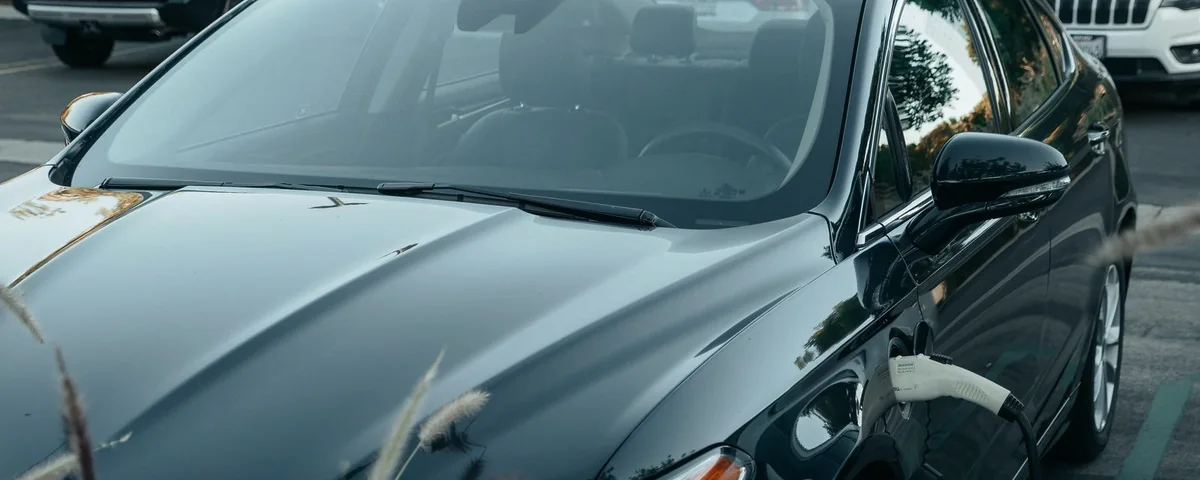 Véhicule électrique branché à une borne de recharge, le connecteur inséré dans la prise de la voiture