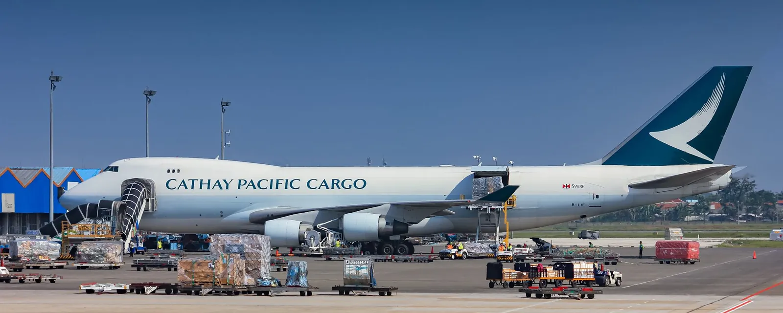 Cargo aircraft being loaded with freight pallets on an airport apron